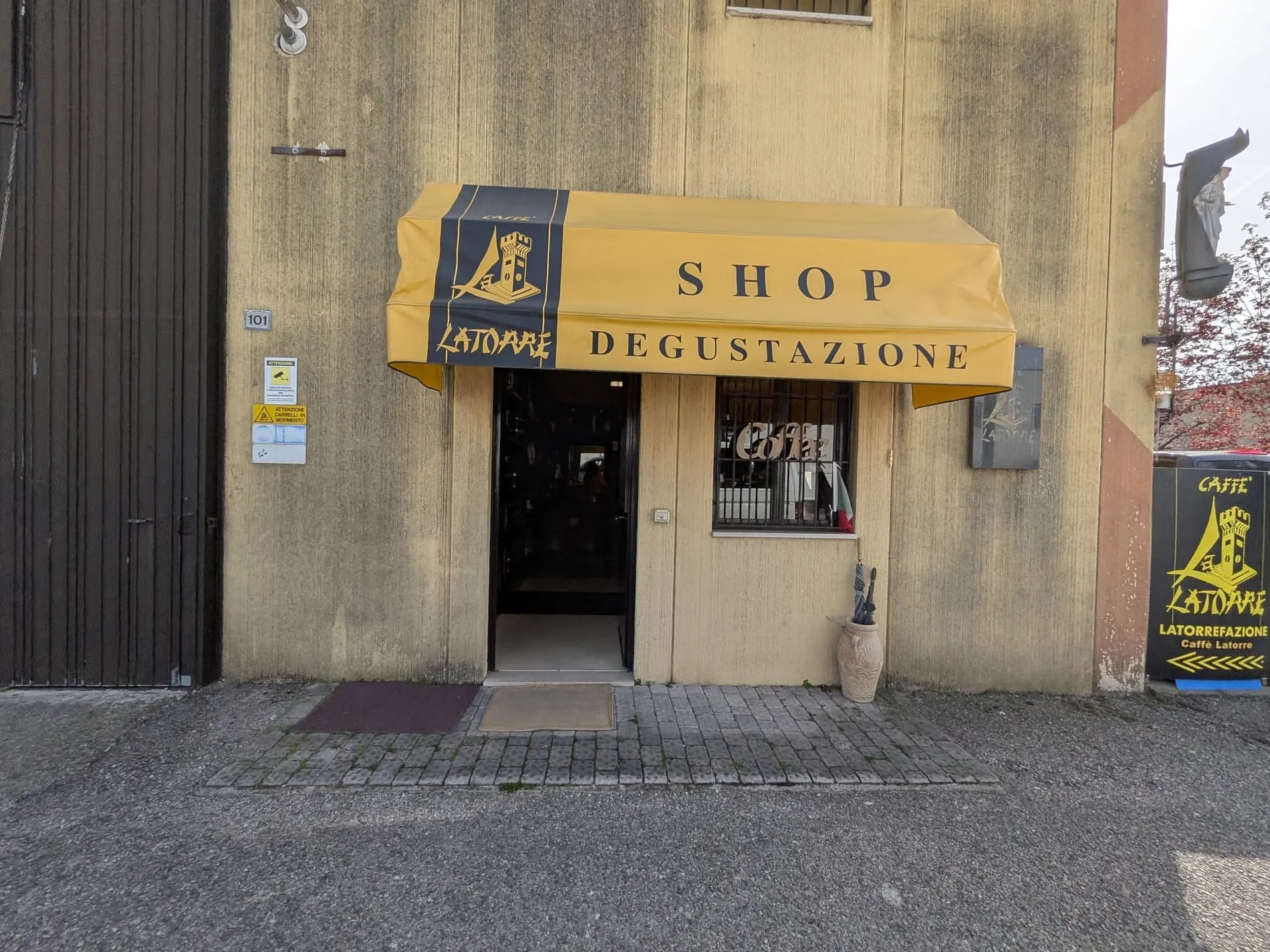 La Torre Espresso Shop und Degustazione am Gardasee – kleine Hinterhof-Rösterei mit gelber Markise im italienischen Industriegebiet