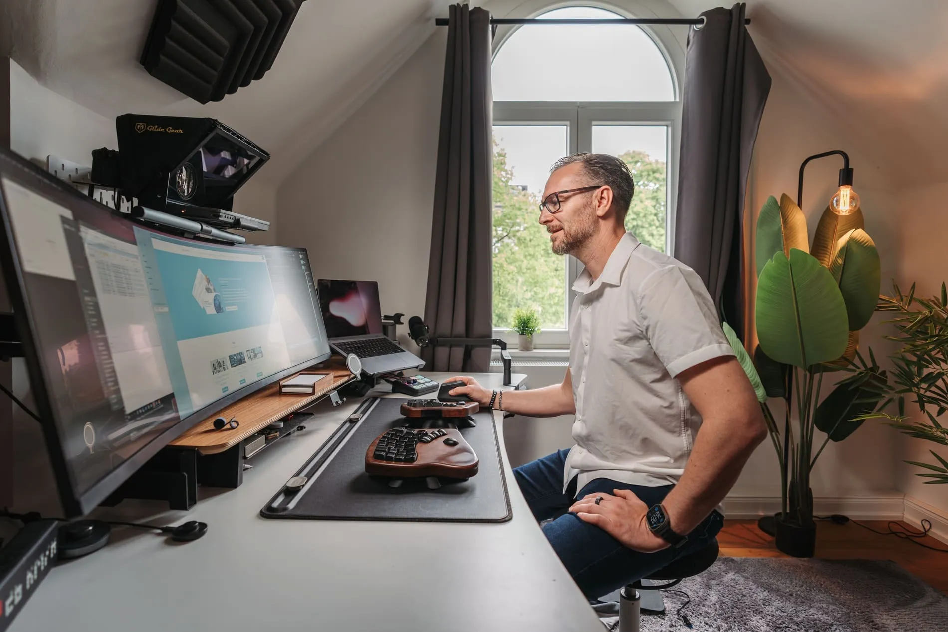 Patrick Lenz arbeitet an seinem Schreibtisch mit mehreren Monitoren im Homeoffice