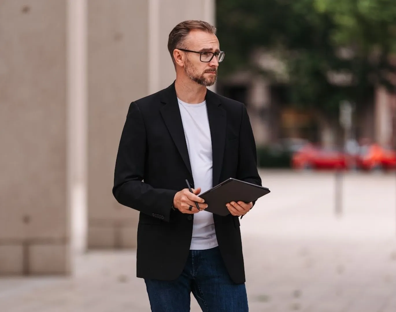 Patrick Lenz arbeitet draußen, weg vom Schreibtisch, mit Blick nach vorne