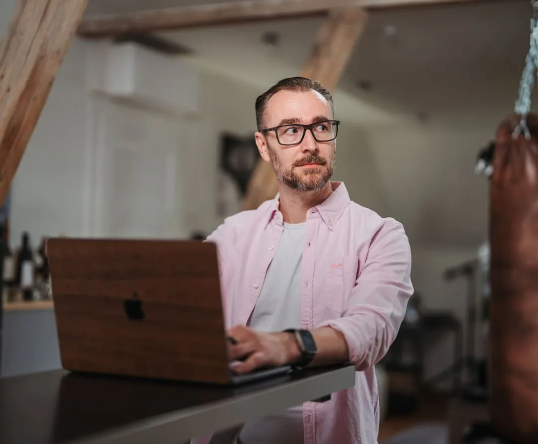 Patrick Lenz steht am Stehtisch und arbeitet konzentriert am Laptop
