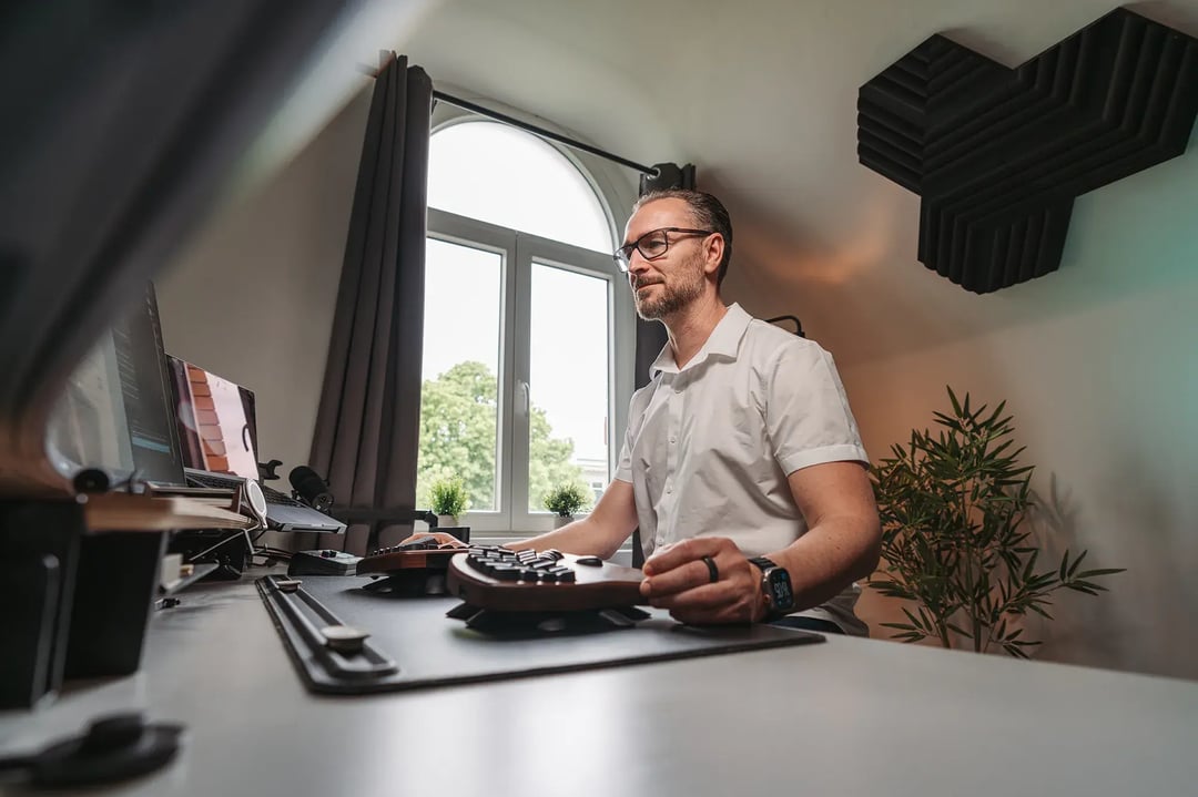 Patrick Lenz konzentriert an seinem Schreibtisch im hellen Büro – fokussiertes Arbeiten an schlanken, individuellen IT-Lösungen für den Mittelstand