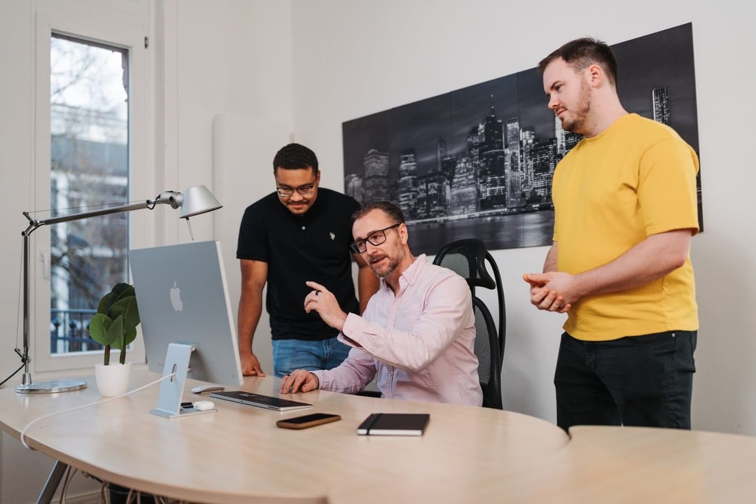 Patrick Lenz von top.media im Gespräch mit zwei Teammitgliedern am Computer – persönliche Implementierung und Beratung statt reiner Software-Lieferung